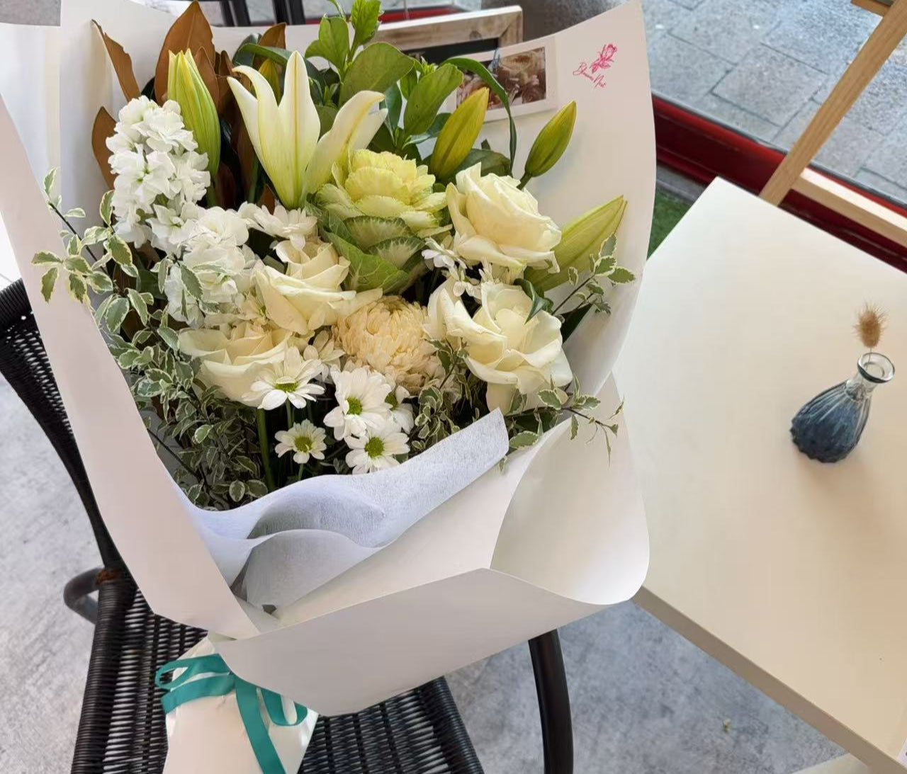 Bouquet of flowers wrapped in white paper.