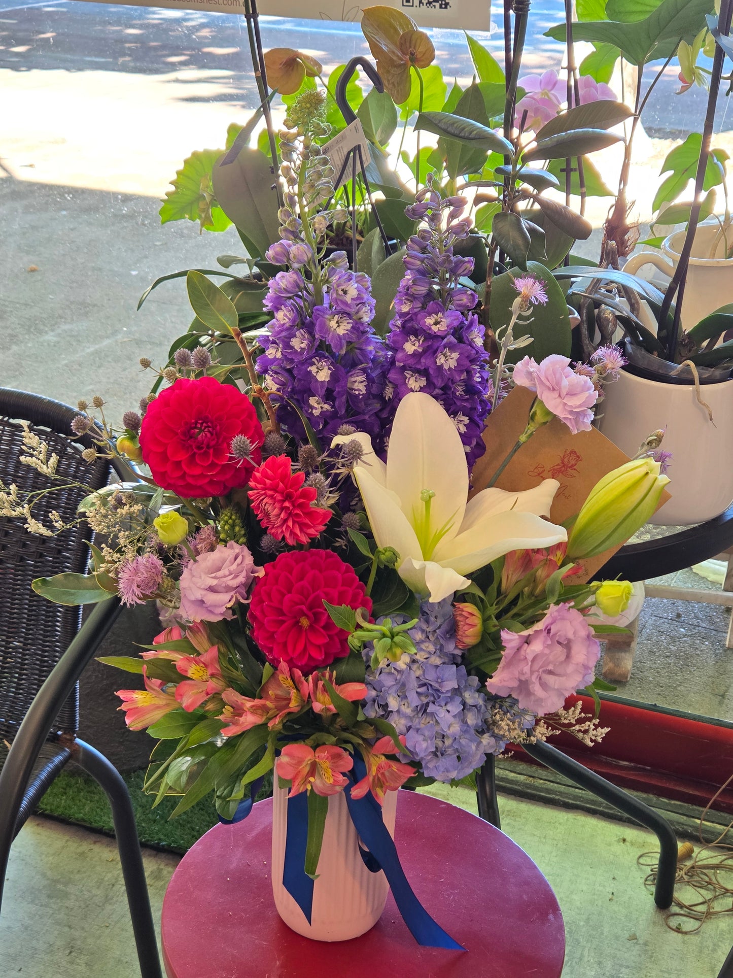 Colorful flower arrangement with pink, purple, and red flowers on a chair.