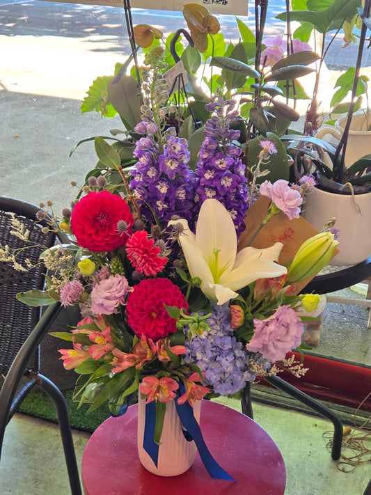 Colorful flower arrangement with pink, purple, and red flowers on a chair.